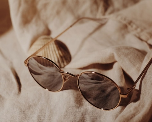 A sepia-toned image of sunglasses on a beach towel