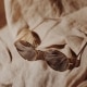 A sepia-toned image of sunglasses on a beach towel